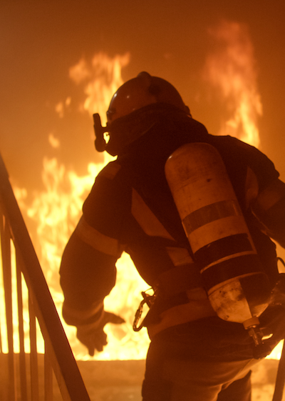 Firefighter going up burning stairs