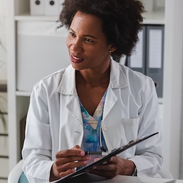 Doctor speaking to patient with clipboard about hepatic artery infusion