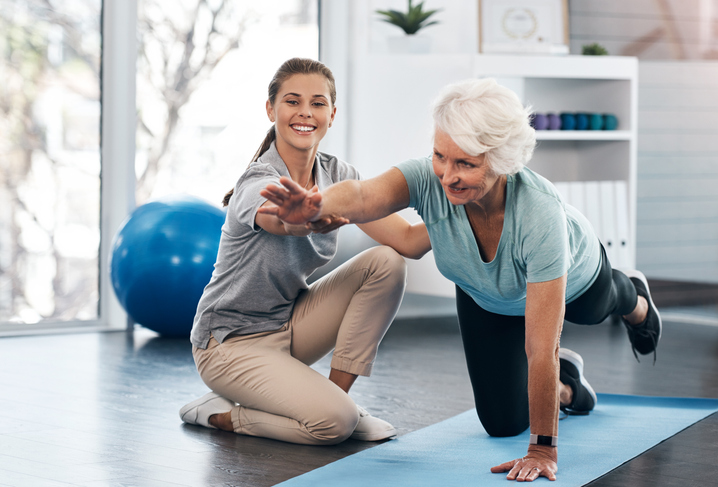 A person doing Yoga with a therapist in a clinic