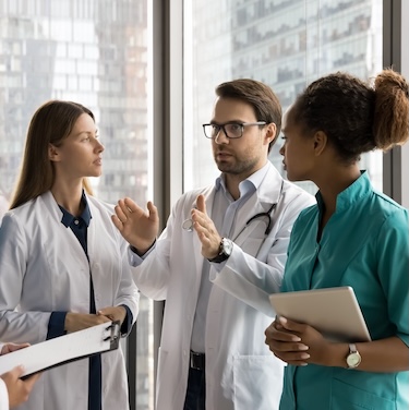 Doctor speaking with team of supporting medical staff